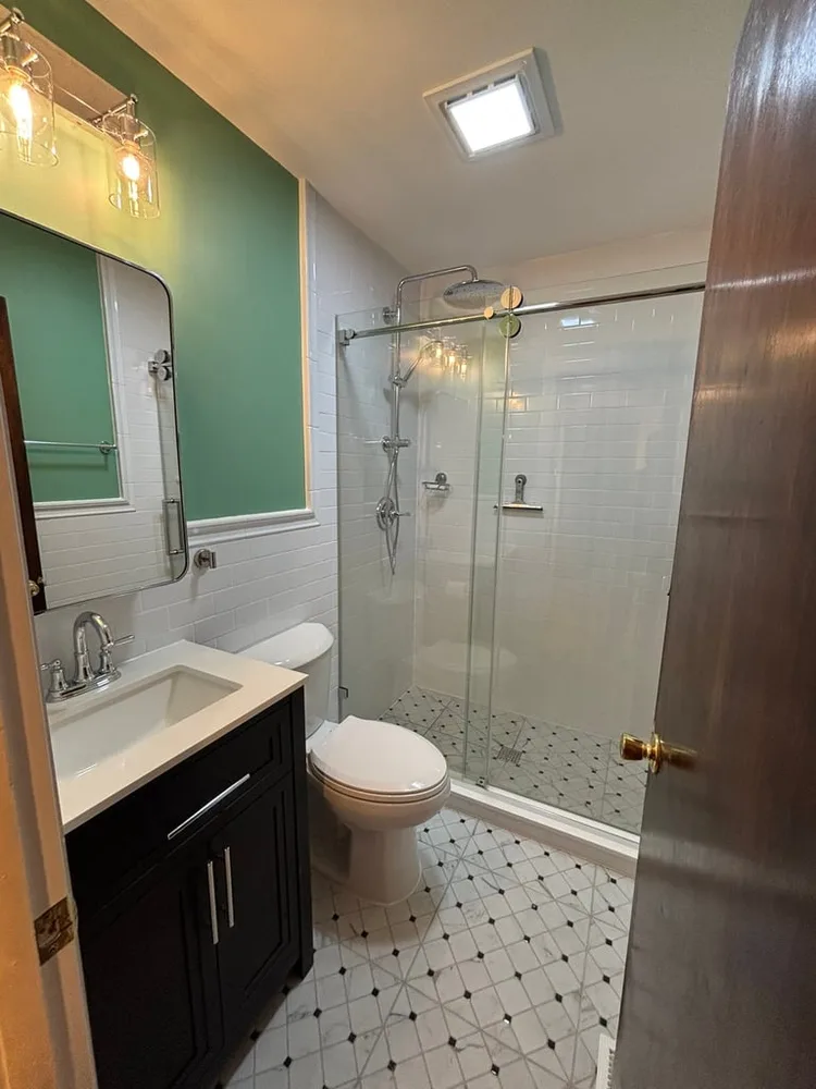 Bathroom remodel by Grand Remodeling — walk-in glass shower with subway tile
