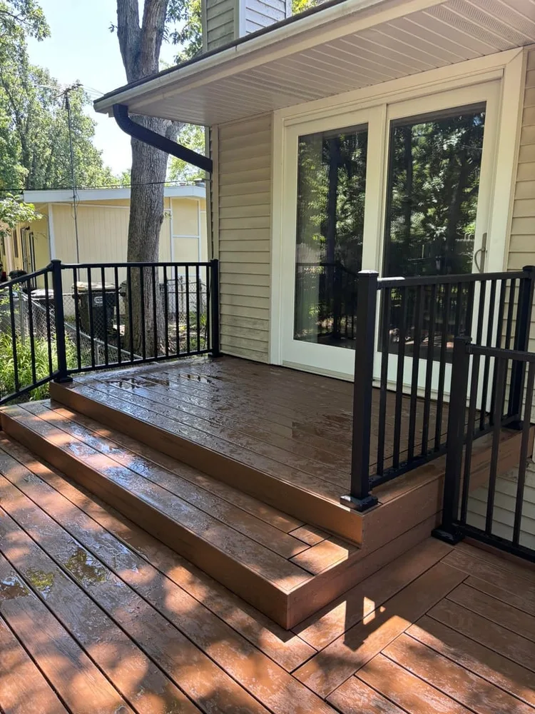 Custom deck build by Grand Remodeling with black metal railings